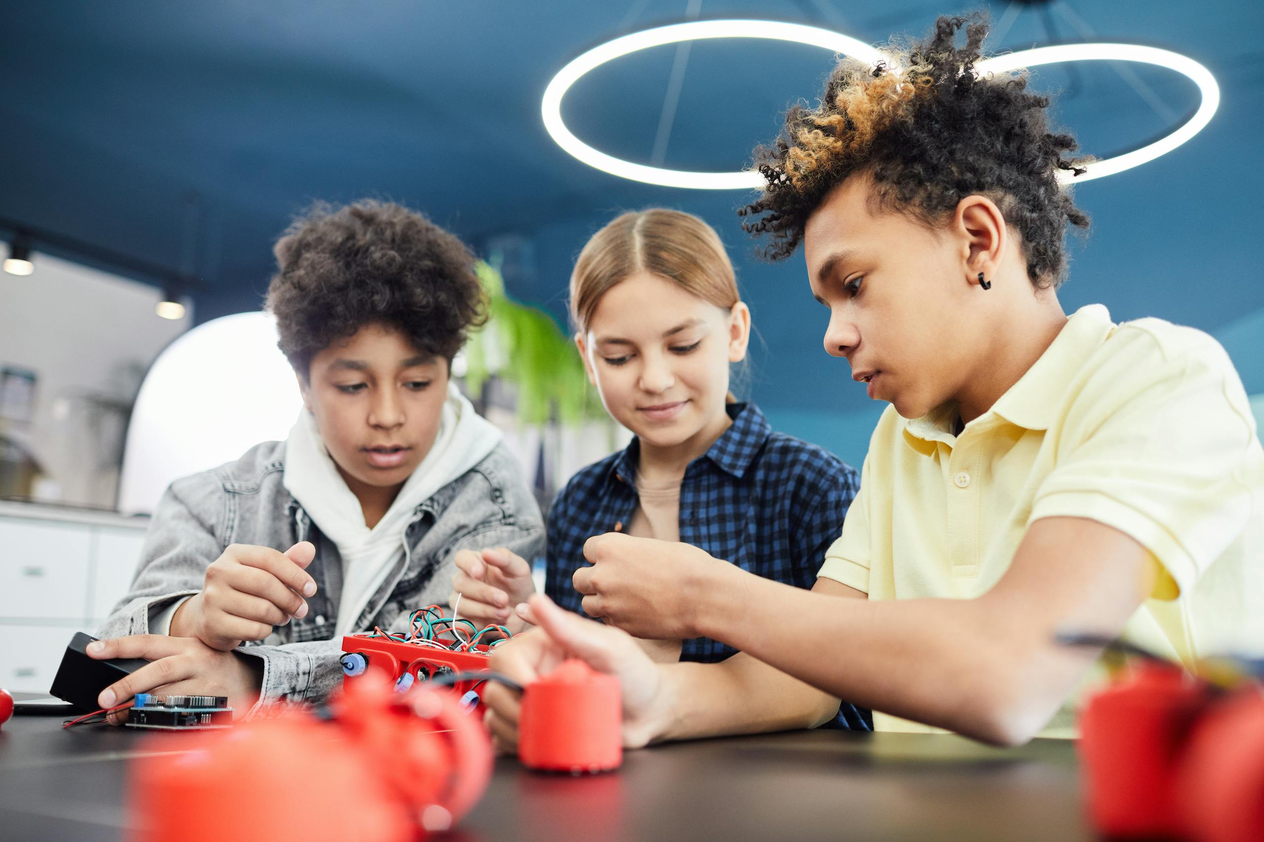 Teenagers working together on a robotics project in a workshop