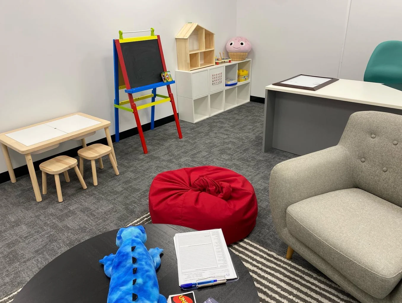 A child-friendly consulting room with a low table, easel and beanbag